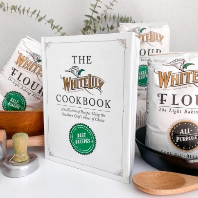White Lily cookbook next to other White Lily merchandise