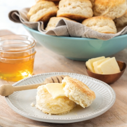 Fresh biscuits on a plate drizzled with honey