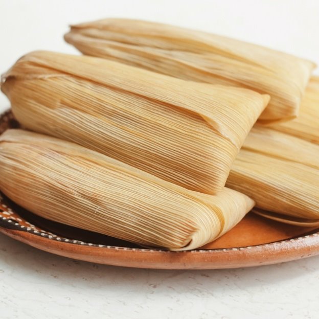 Freshly cooked tamales wrapped inside of corn husk