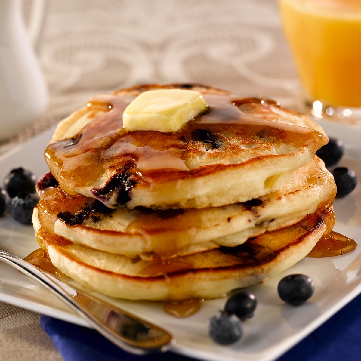 Fluffy blueberry pancakes with a taste of lemon. Topped with syrup, butter and more blueberries